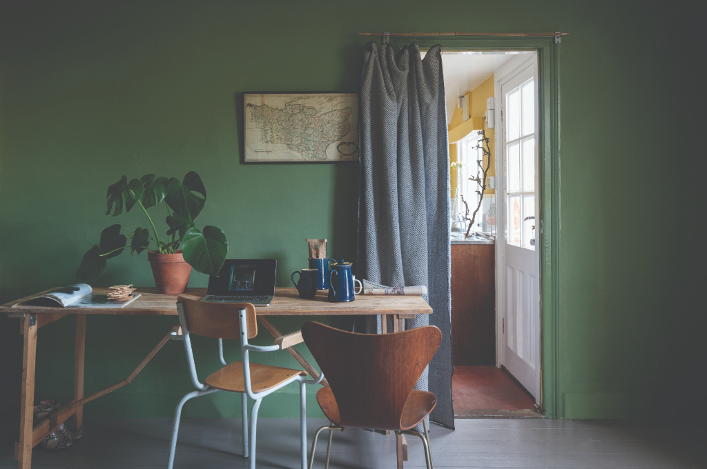 壁をNo.34 Calke Greenでペイントしたワークスペース。木目を生かしたデスクやチェア、卓上に置かれたモンステラの観葉植物とも相性よく、目を酷使しがちな現代人にはグリーンのインテリアは心身ともに癒しを与えてくれます。