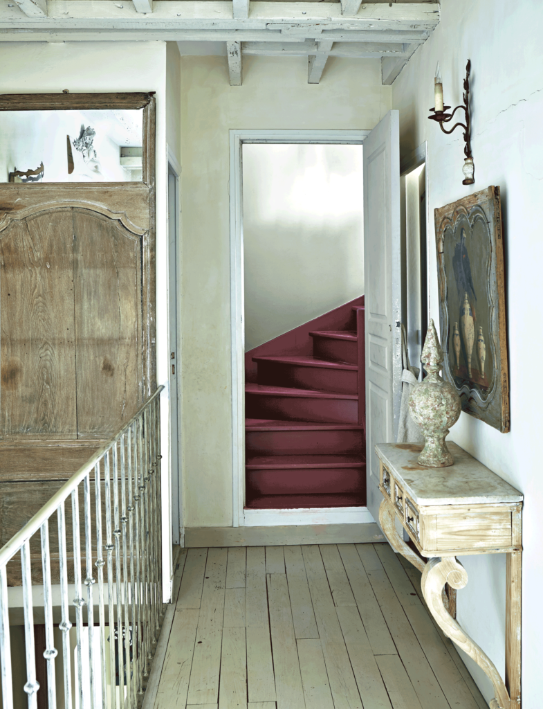 手前床：No.4 Old White / 階段床：No.43 Eating Room Red / 落ち着きのあるベージュ系の色を手前の空間の床に、シックな赤を階段の床面に塗装。手前のナチュラルな空間から見ると、赤い階段スペースはドラマチックに変化しているのがわかる。