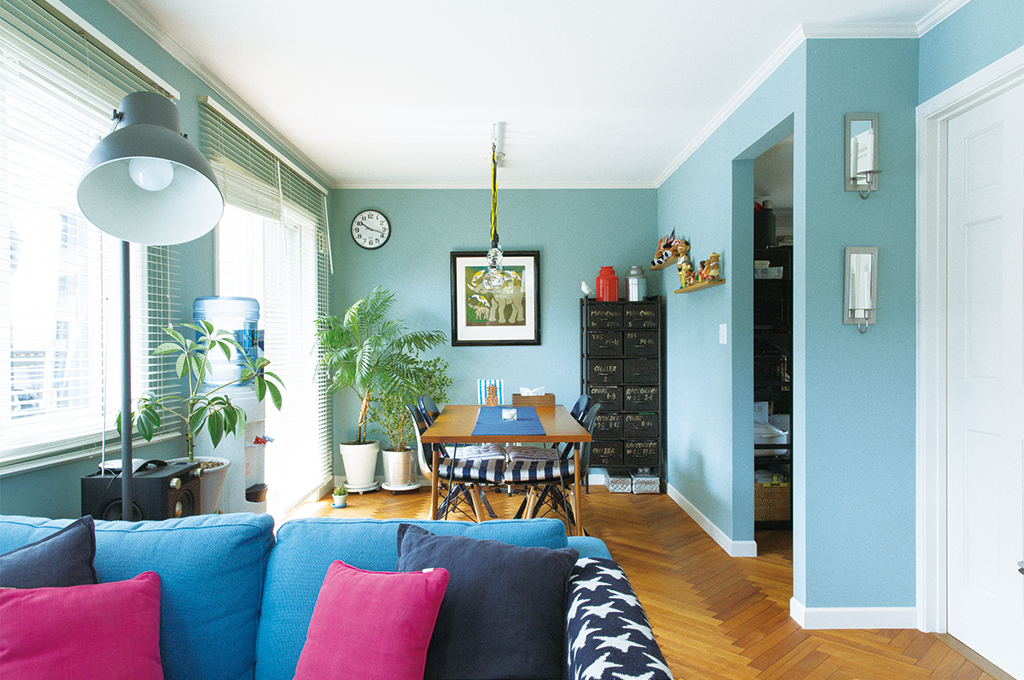 鮮やかなブルーの壁面が印象的な、Farrow&Ballのペイントで彩られたリビングダイニング。ヘリンボーンの床やカラフルな家具、観葉植物が調和し、遊び心溢れる北欧モダンな空間を演出しています。自然光に映える美しい発色が、お部屋を明るく開放的に彩ります。