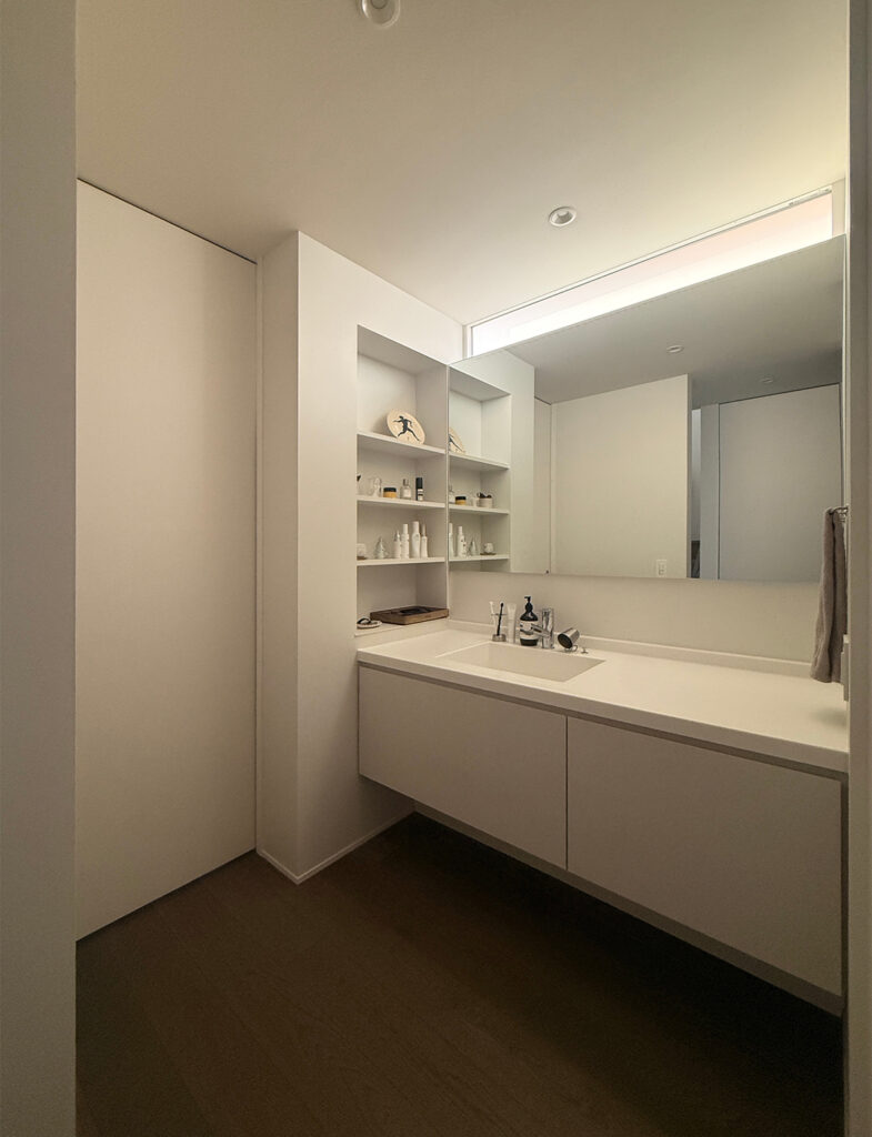 清潔感のある白で統一されたサニタリー。大きな鏡と塗装壁が広がりを感じさせる。No.2001 Strong White（ストロングホワイト）