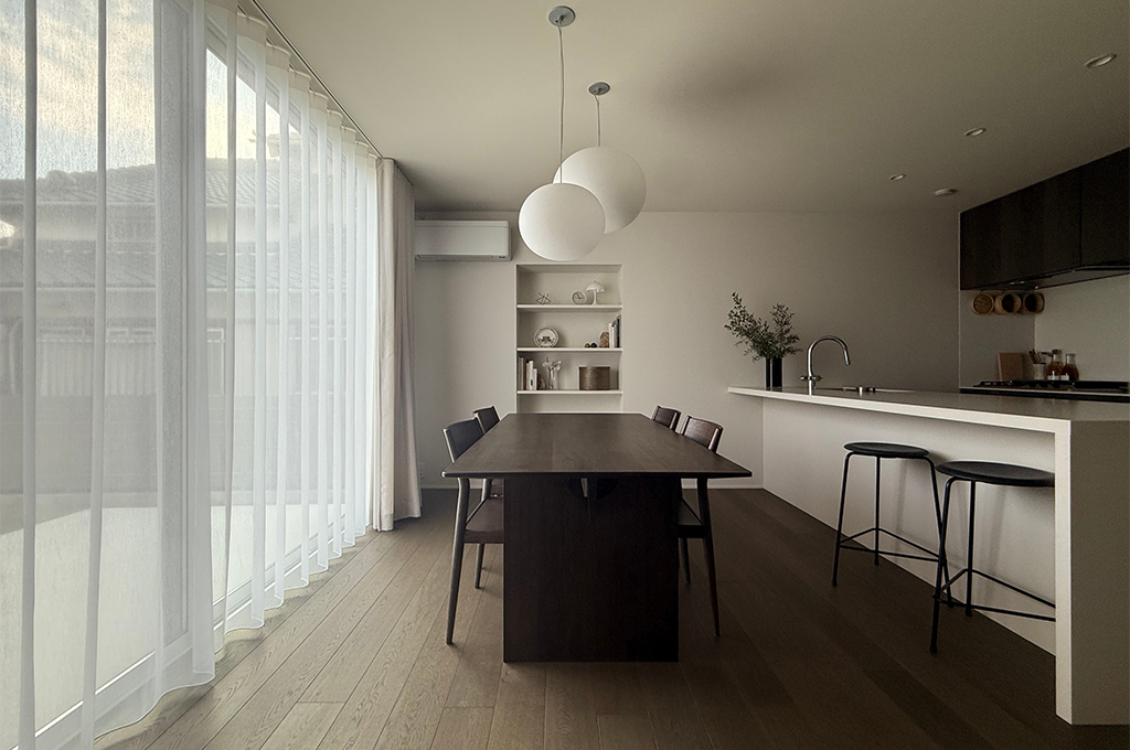 キッチンカウンターのディテール。ミニマルな水栓と枝物が白い背景に美しく映える。No.2001 Strong White（ストロングホワイト）