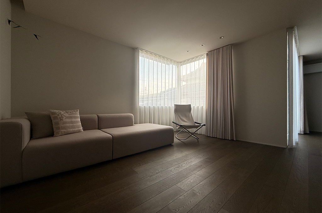 リビングのソファスペース。広々とした白い壁が、落ち着いたリラックス空間を演出。No.2001 Strong White（ストロングホワイト）