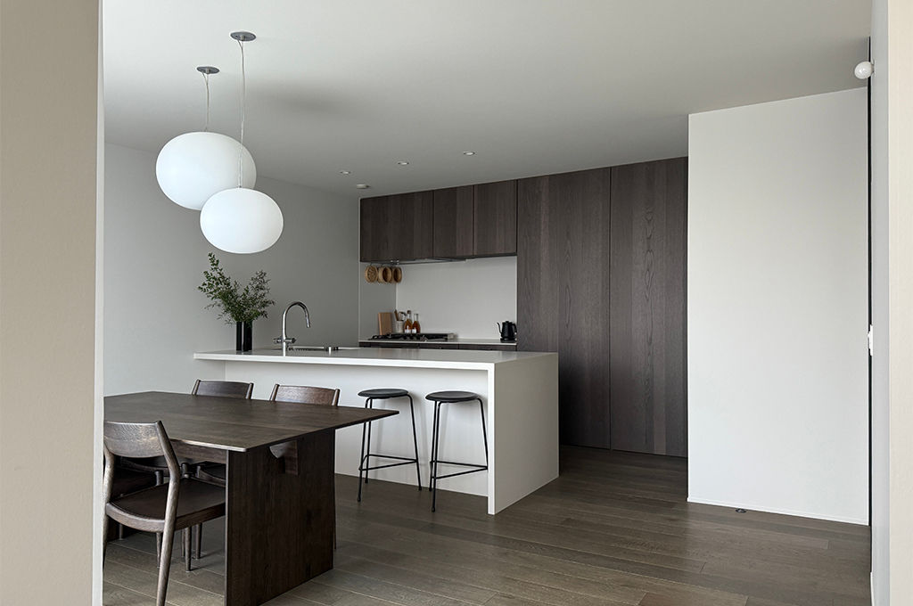 キッチンカウンターのディテール。ミニマルな水栓と枝物が白い背景に美しく映える。No.2001 Strong White（ストロングホワイト）