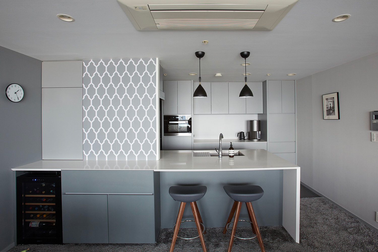 Farrow & Ballの壁紙「Tessella」とグレーペイントが調和するモダンなキッチン。洗練された配色のアクセントウォールが、ワインセラーのある上質なLDK空間を引き立てるマンションのリノベーション施工例。