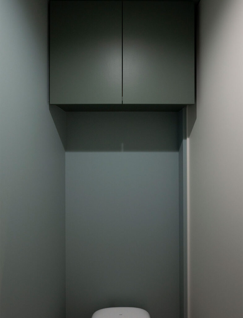 シックなブルーグレーが空間を引き締める、ミニマルでモダンなトイレの吊り戸棚収納インテリア。