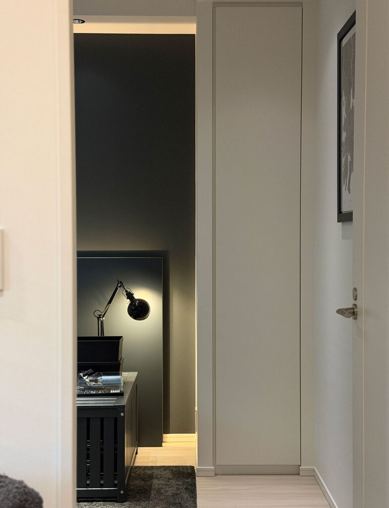 Farrow & Ballの「Hopper Head」で仕上げた寝室のヘッドボード壁。深みのあるチャコールグレーと間接照明が、心地よく洗練されたモダンな眠りの空間を演出。