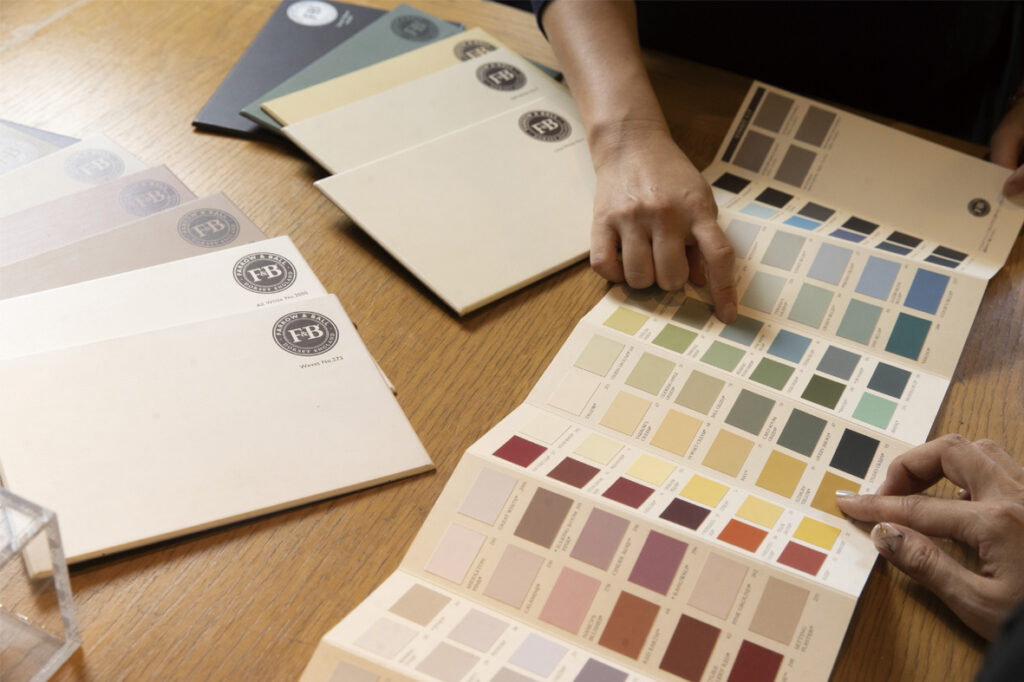 ワークショップ「Life Color Workshop」で、色見本とワークシートを広げたり、カラーチップを選ぶ手元